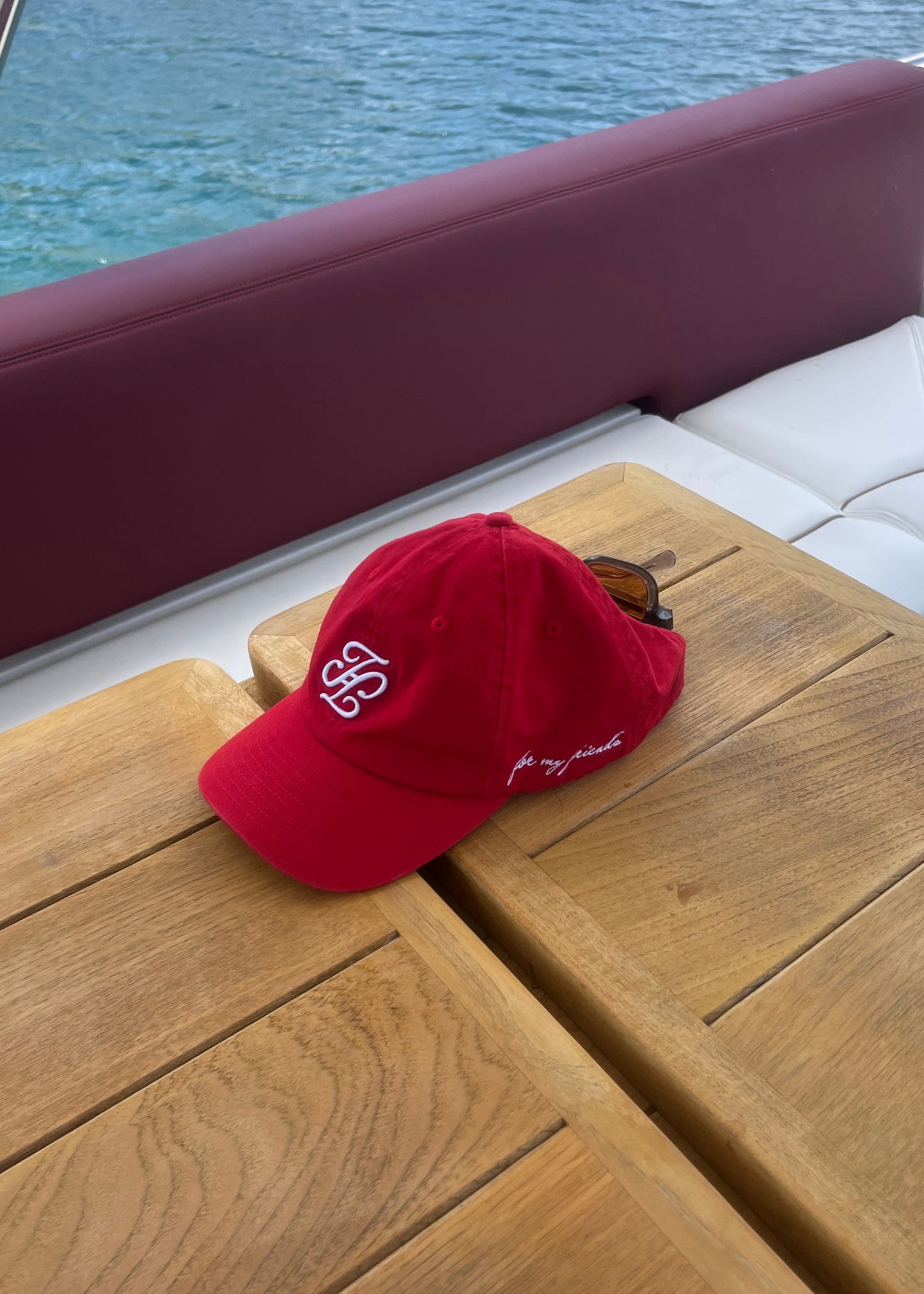 Red cap on a wooden surface with water in the background